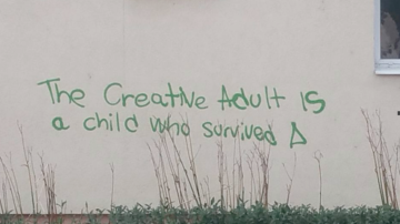 Graffiti saying 'the creative adult is a child who survived'