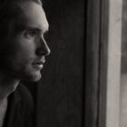 Man looking through window