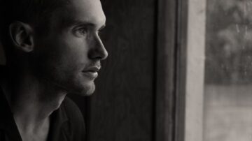 Man looking through window