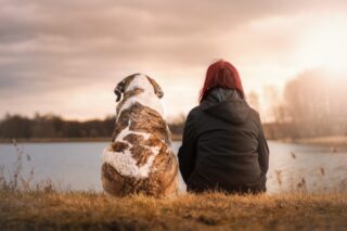 Woman and her dog by a river