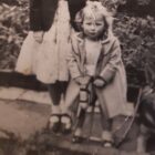 old black and white photo of a little girl and her Alsatian