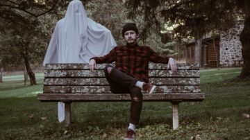 ghost stood behind a man on a bench