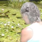 woman looking into a lily pond