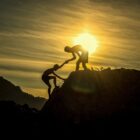 one person helping another up a hill