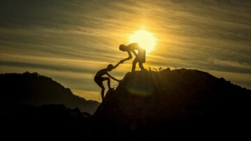 one person helping another up a hill