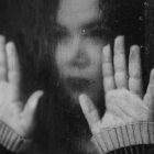 girl trapped behind glass