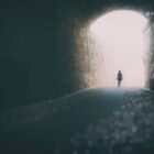 A lone person emerging out of a tunnel