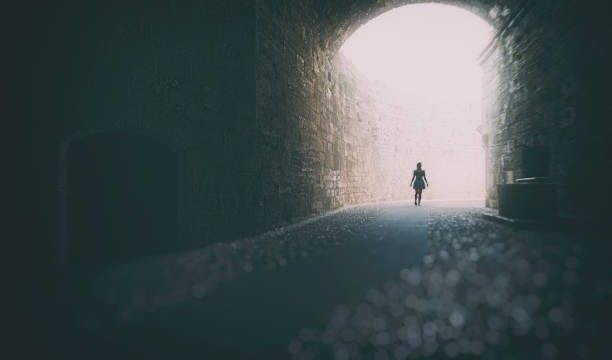 A lone person emerging out of a tunnel