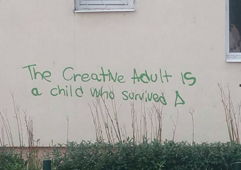 Graffiti saying 'the creative adult is a child who survived'