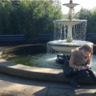 girl sitting by fountain