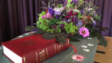 coffin with flowers and bible on top