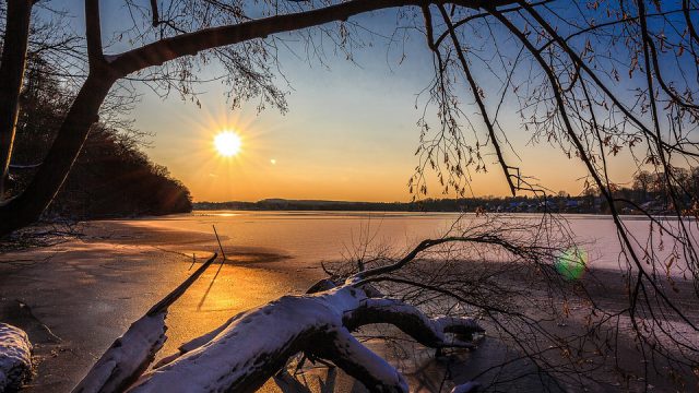 low sun shining over a frozen lake