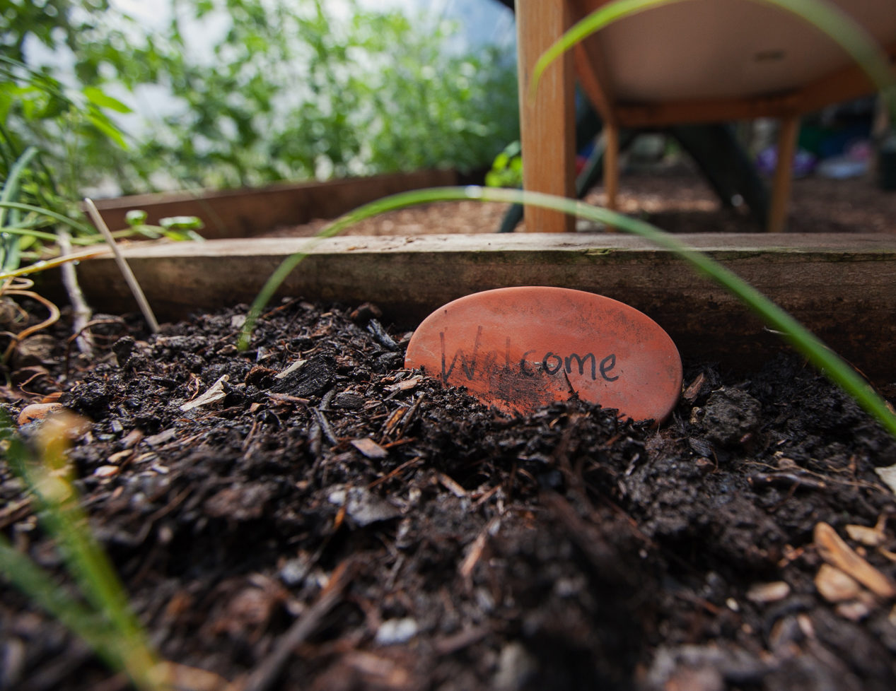 Welcome sign in a flowerbed