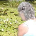 woman looking into a lily pond