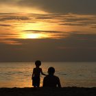 father and son looking at sunset