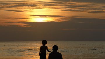 father and son looking at sunset