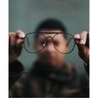 Out of focus Black man holding glasses