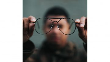 Out of focus Black man holding glasses
