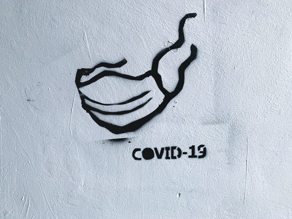 Graffiti of a mask and the words COVID-19.