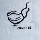 Graffiti of a mask and the words COVID-19.