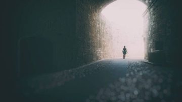 A lone person emerging out of a tunnel